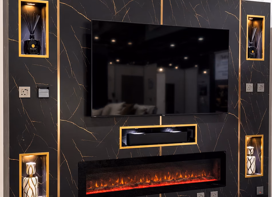 Black and gold marble media wall with a soundbar recess, lit niches and an electric fire